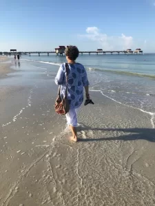 Photo of a woman walking barefoot on the beach
